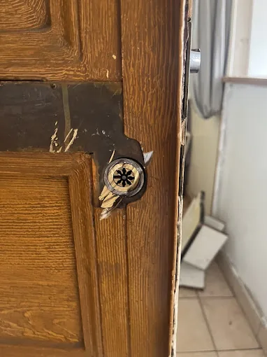 Cylindre endommagé sur une porte en bois après une tentative d'effraction