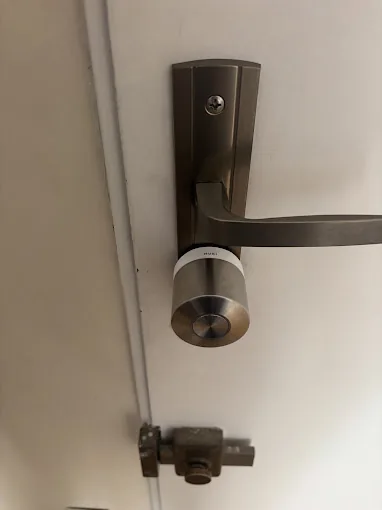 Cylindre de serrure neuf posé sous une poignée de porte