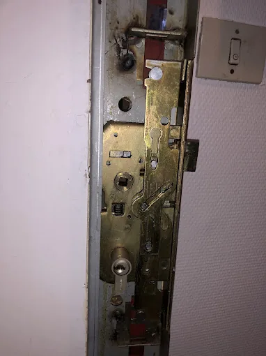 Mécanisme de serrure multipoints à larder visible dans le chant de la porte
