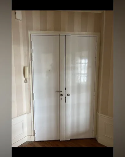 Porte d'appartement à deux battants peinte en blanc