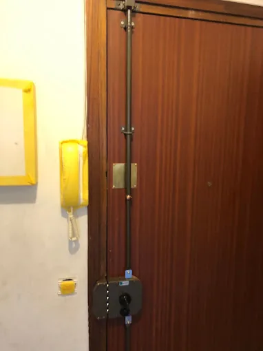 Verrou en applique posé sur une porte d'entrée en bois